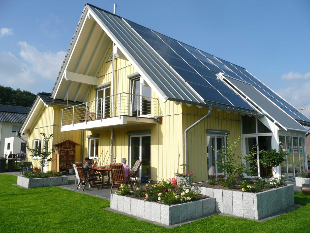 Holzhaus, aufgehängter Balkon, Balkonüberdachung, Holzfassade, In-Dach-PV-Anlage