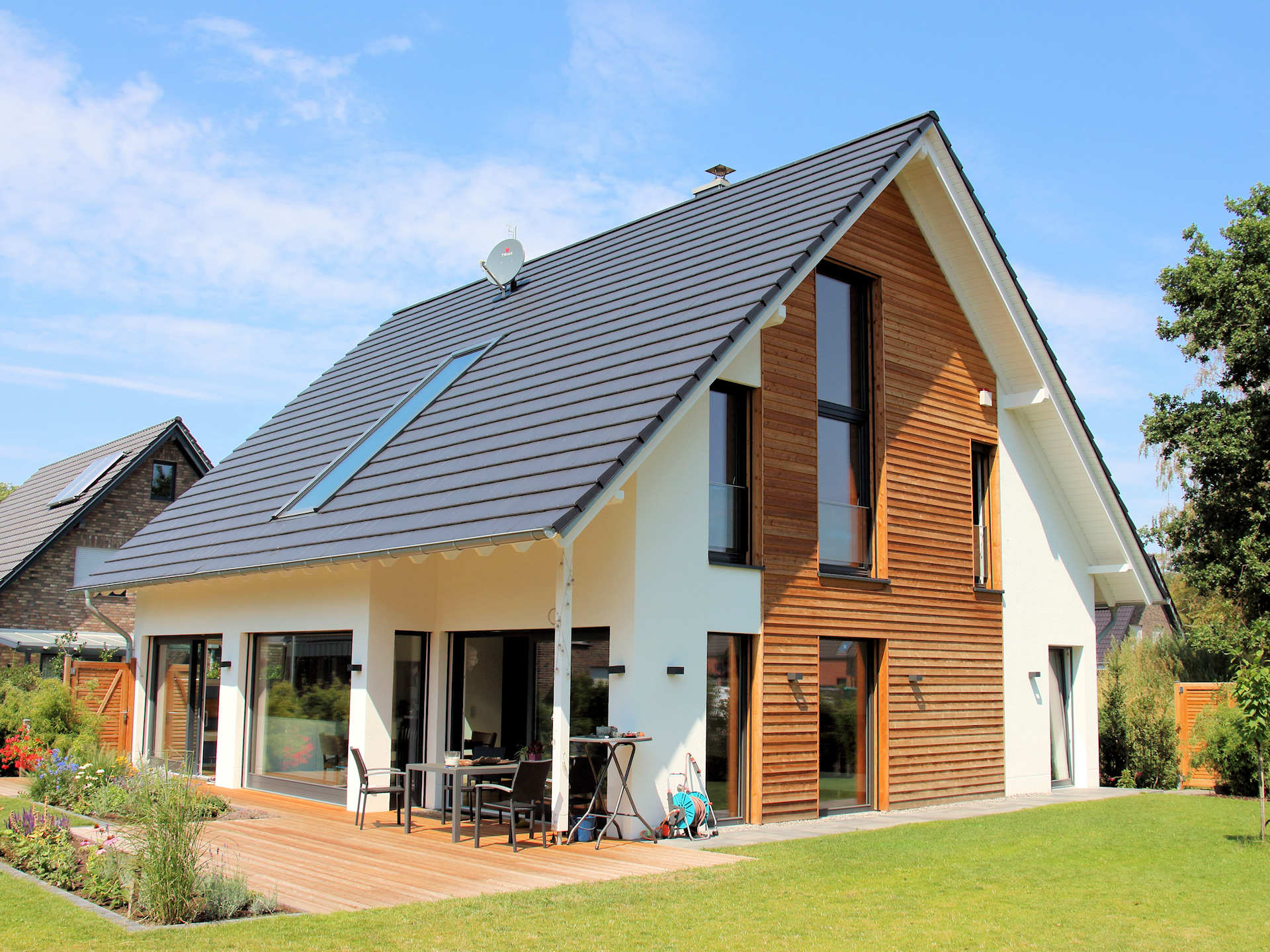 energieeffizientes Holzhaus mit Putzfassade und Holzschlaung